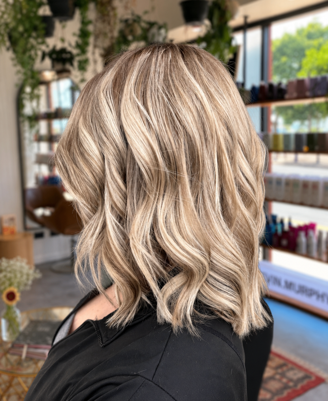 Blonde highlights styled in soft waves inside Salon NB