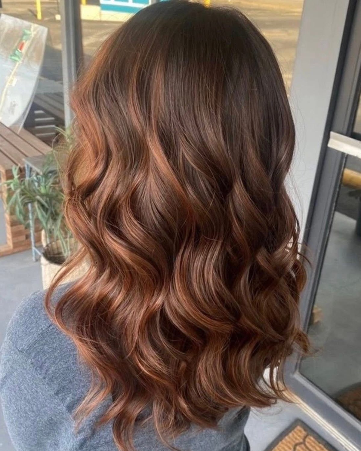 Salon NB copper brunette waves styled near the salon window