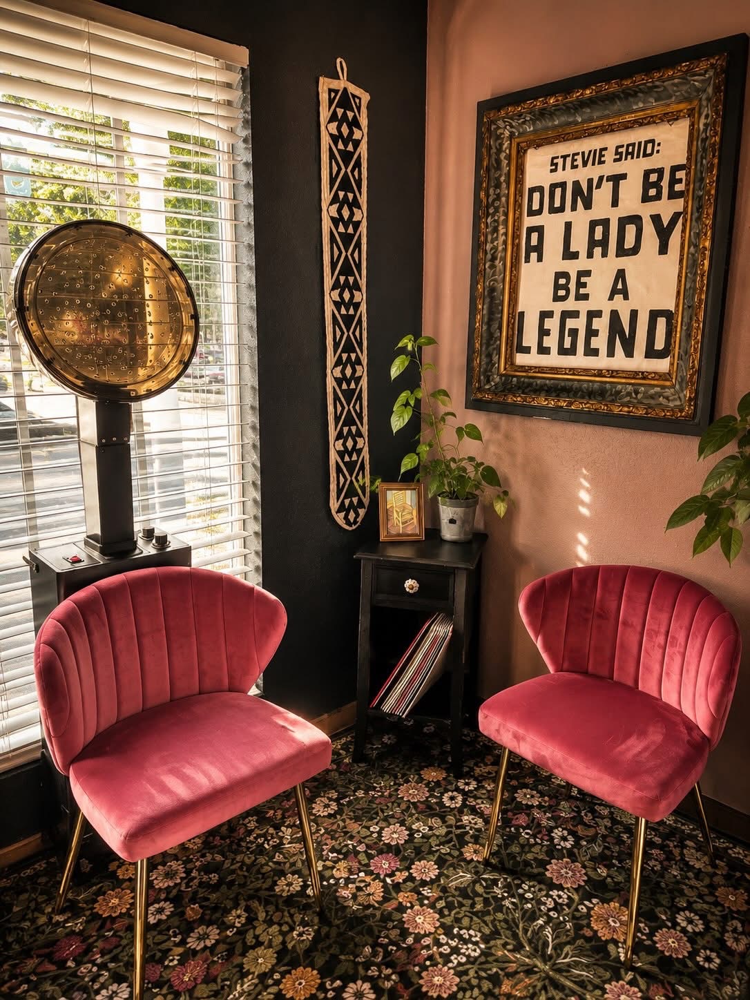 Salon NB lounge corner with pink chairs, plants, and framed wall art